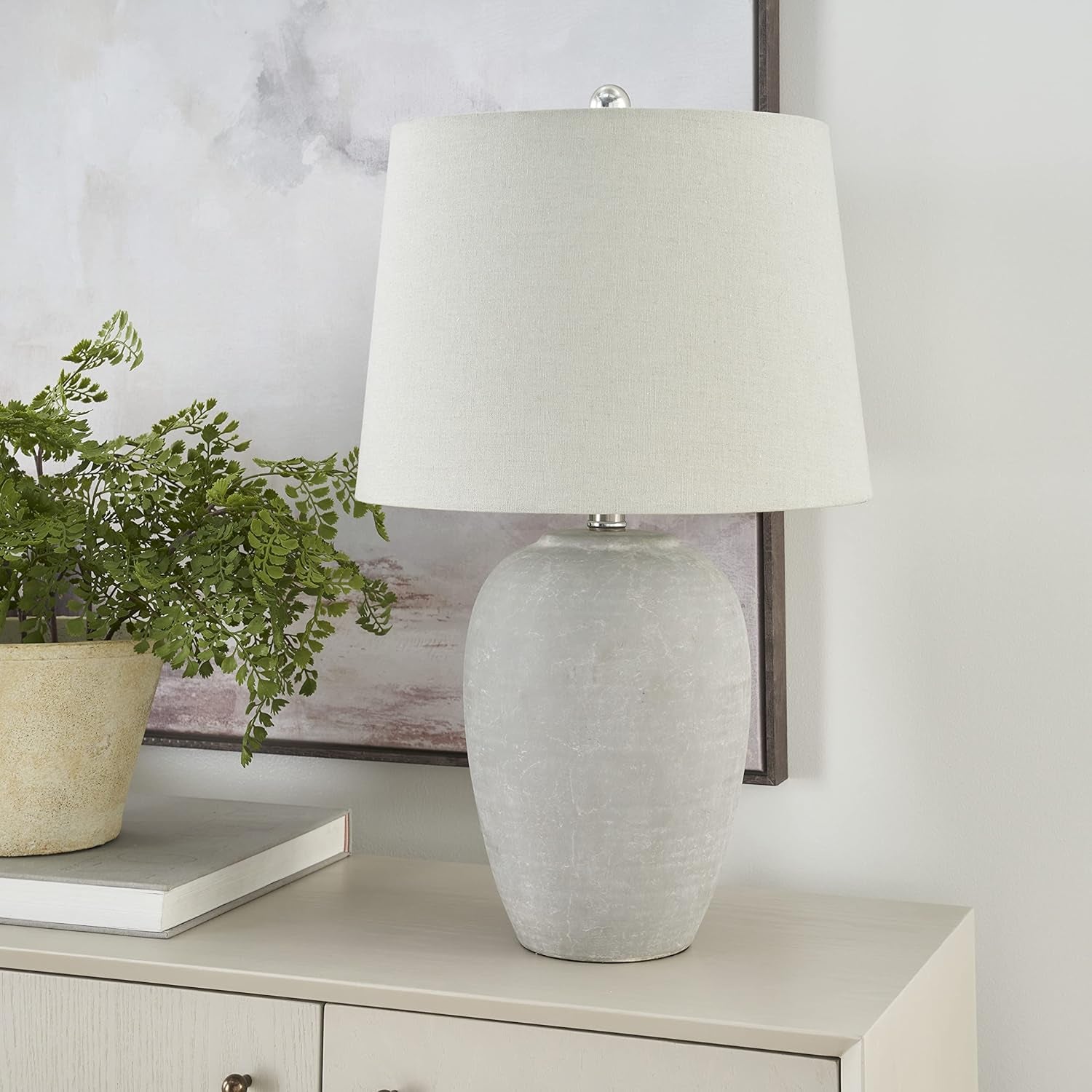 Vintage gray ceramic table lamp with a light gray linen shade on a modern side table.
