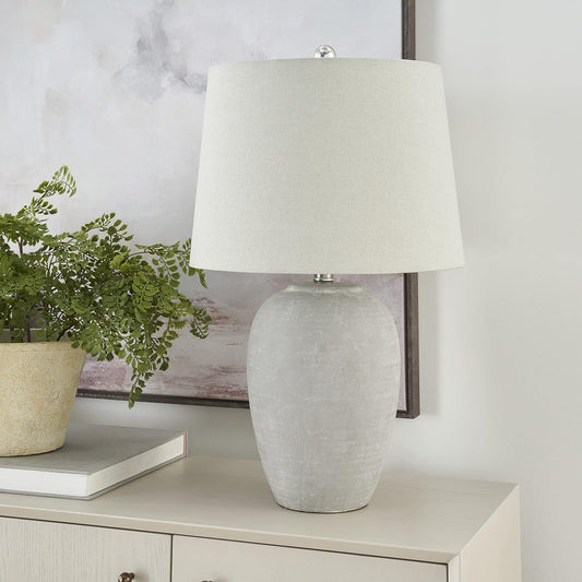 Vintage gray ceramic table lamp with a light gray linen shade on a modern side table.
