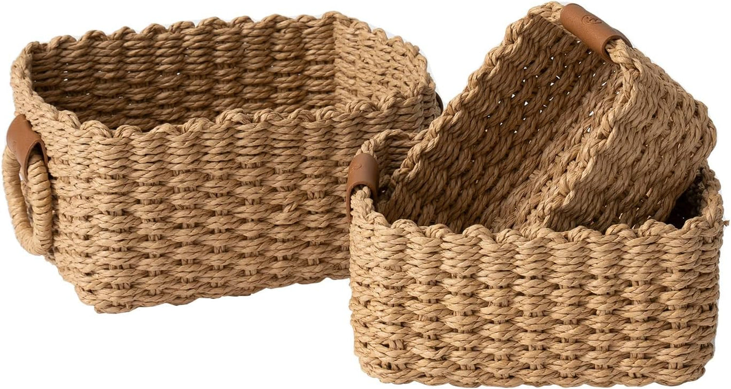 Set of three woven wicker storage baskets with round handles and decorative vegan leather tags.
