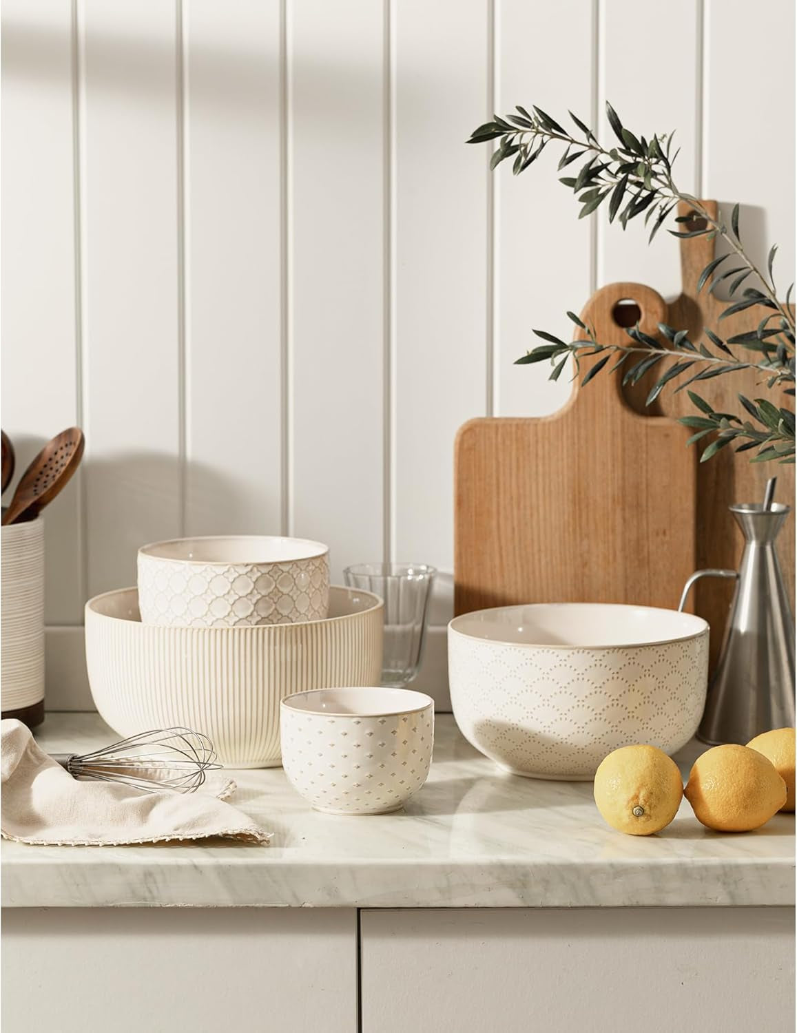 Embossed ceramic mixing bowls displayed on a modern farmhouse kitchen countertop.
