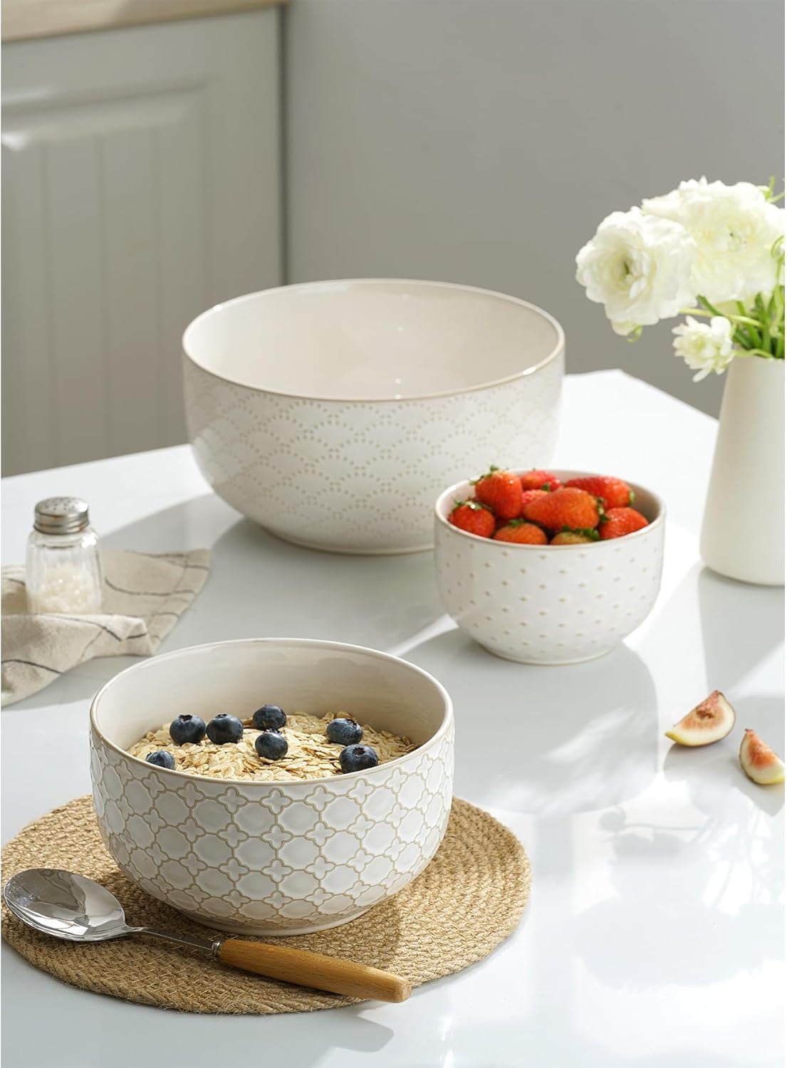 Large embossed ceramic serving bowl filled with fresh fruit.