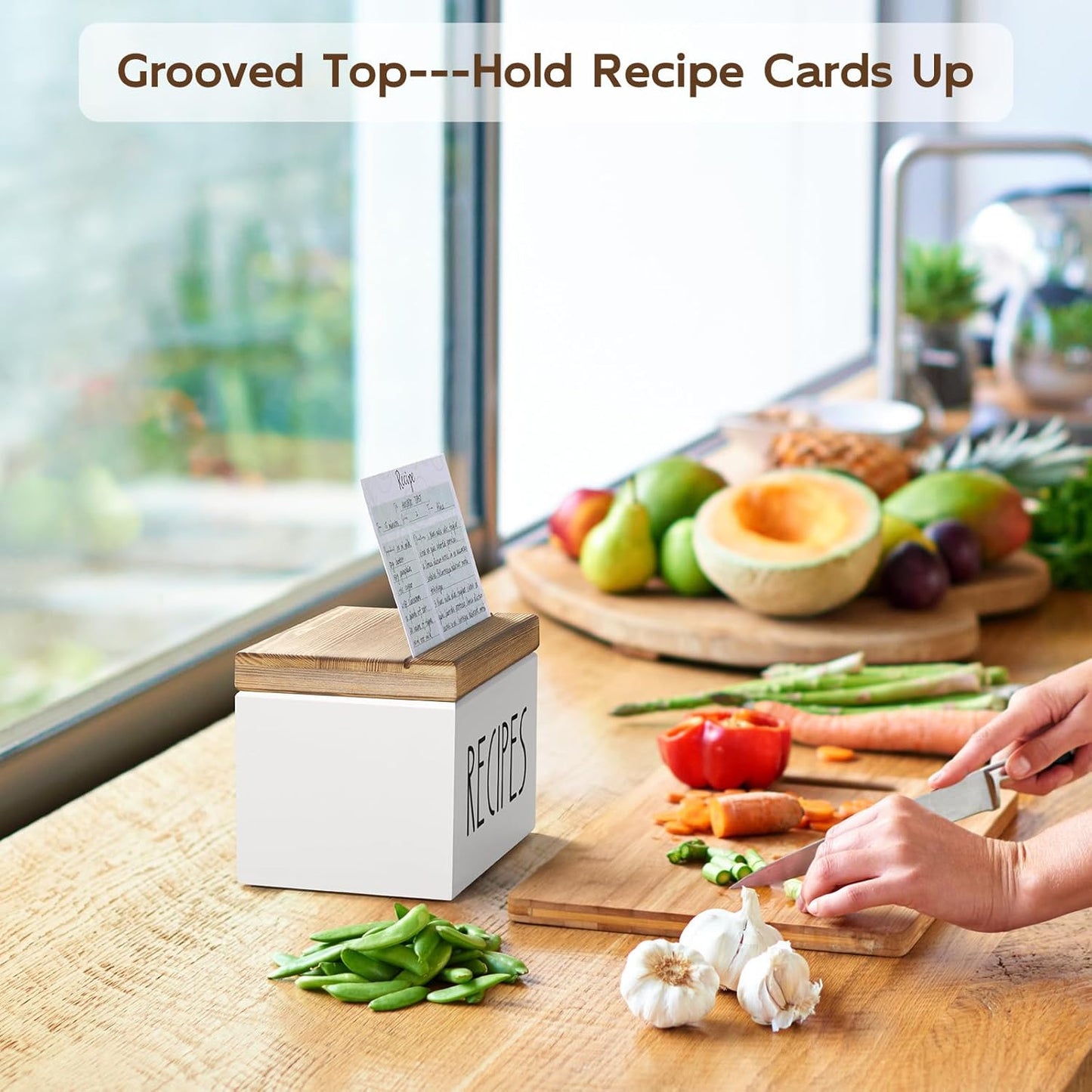 White farmhouse recipe box with built-in recipe card holder displayed on a kitchen countertop during meal preparation.